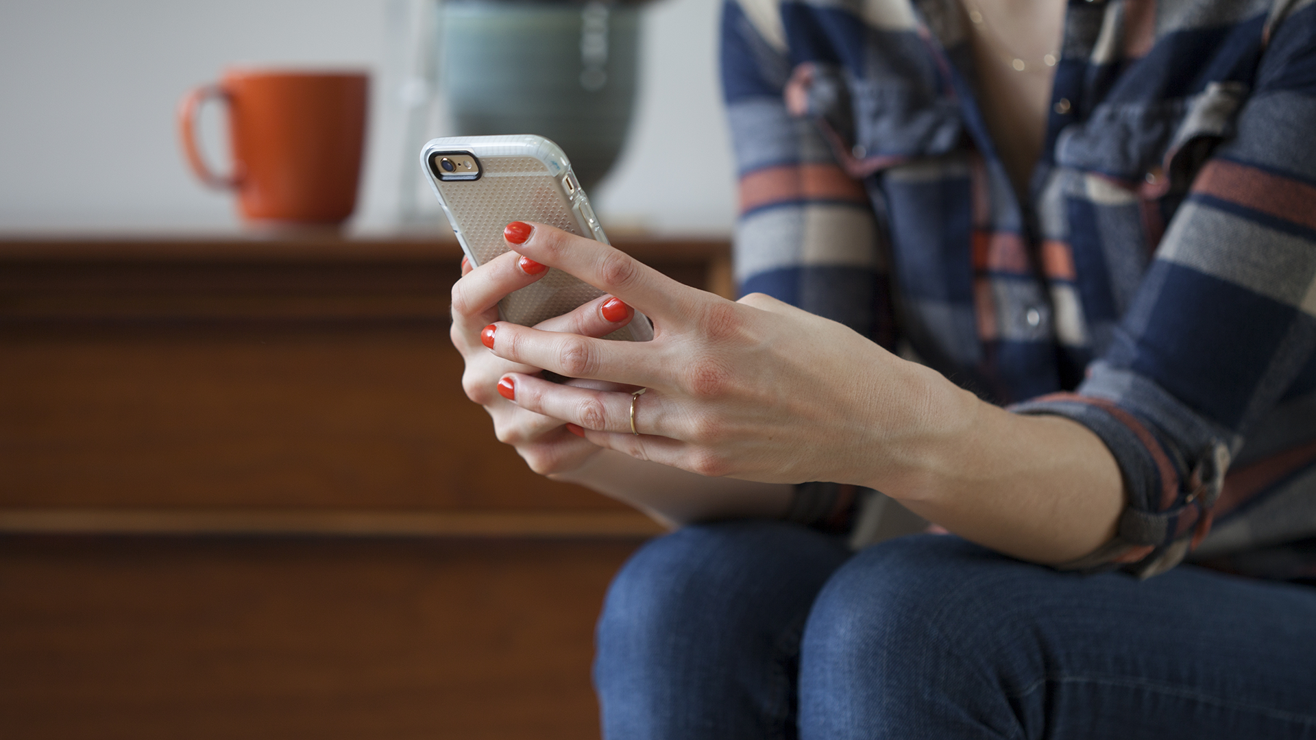 A color photo showing a woman's hands holding a phone. Shutterstock image