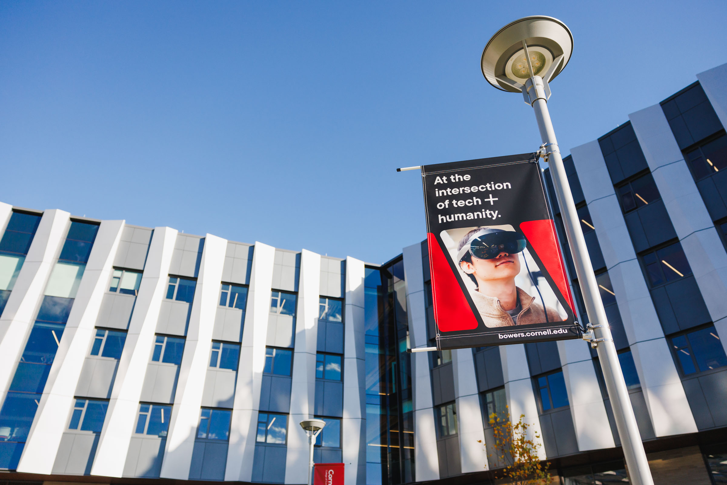 Upward angle of new silver building with black and red flagpole